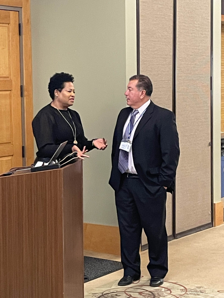 Regina Owens stands and talks to Superintendent Olmos.