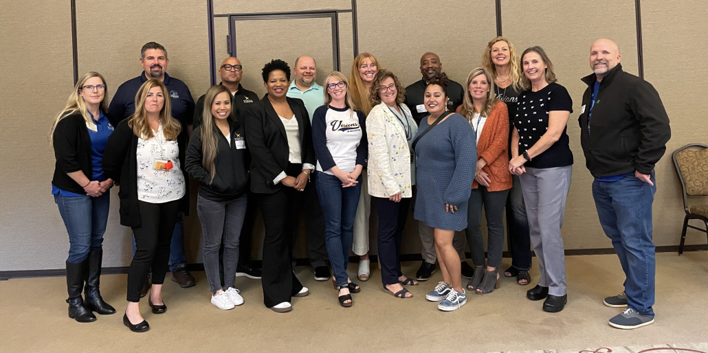 Visions leadership stand together with Regina Owens for a group photo.