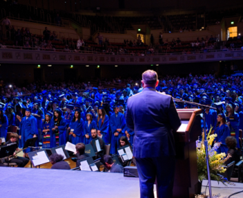Superintendent looks out into the crowd of graduates from the podium at graduation