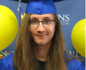 Male graduate smiling at the camera with cap and gown