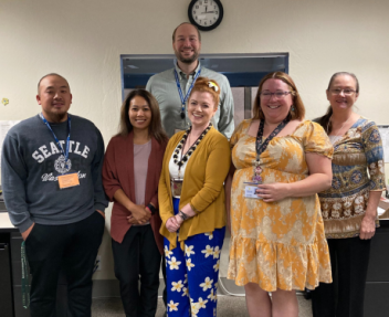 6 Fiscal Services team members gather together for a staff photo in their office area.