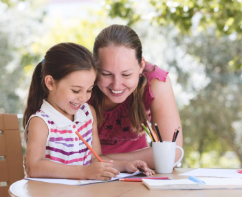 Homeschooling mom working with daughter on schoolwork at home