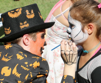 Student enjoying face-painting at a Harvest Festival
