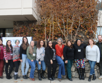 All instructional support staff, including Office Coordinators, Charter School Secretaries and Administrative Assistants, stand together in a line in front of Visions' office building.