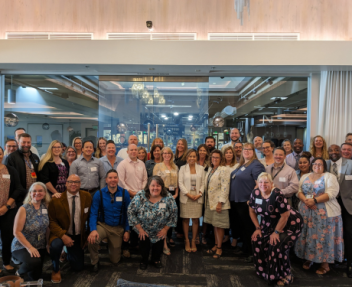 Large group of Visions leaders, administrators and managers gather and smile for a group photo