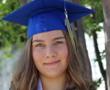 Marina smiles at the camera in blue graduation cap and gown; graduating from online high school