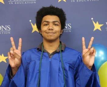 Lenny, eSports champ, Visions graduate and STS staff member gives the peace sign at high school graduation