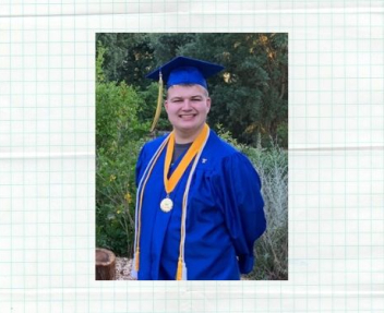 Male online high school graduate smiles at the camera wearing a blue cap and gown