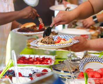 Guests filling plates at a summer cookout