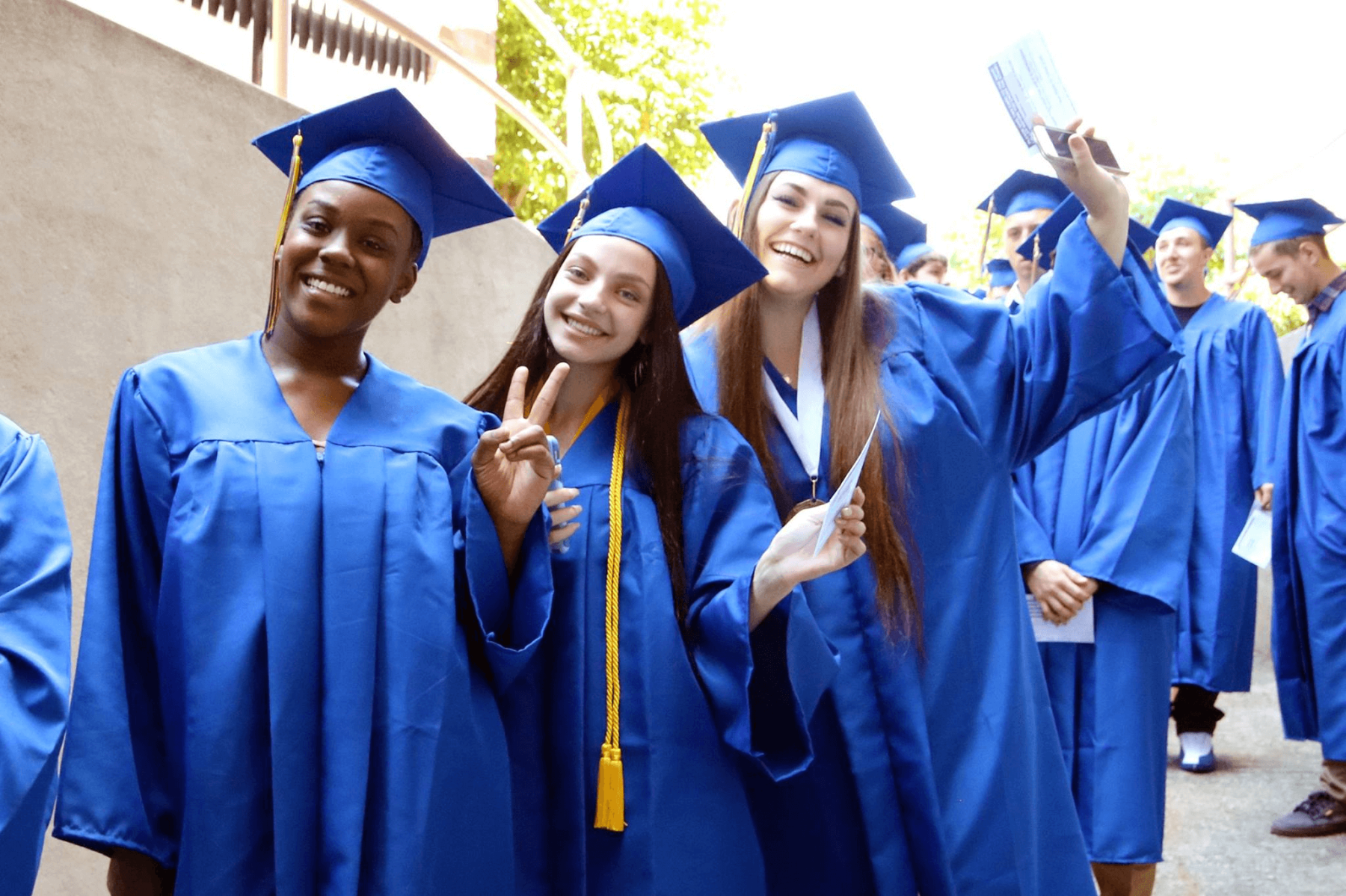 A cheerful gathering of graduates in blue gowns and caps, proudly celebrating their graduation day.