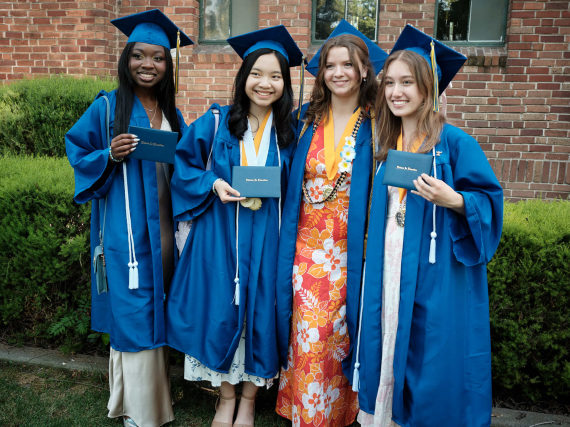 A cheerful gathering of girls in graduation gowns and caps, proudly marking their special day.