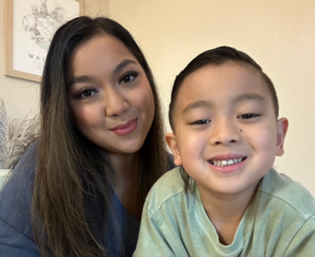 Smiling parent educator and her home school student read a book